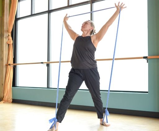 A MOVE Pilates Instructor stretching with bands